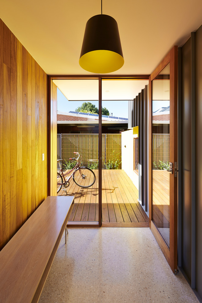 Inspiration pour une entrée design avec un vestiaire, un mur marron, une porte simple et un sol beige.