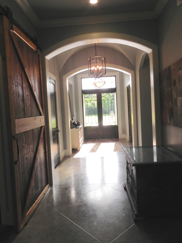 Photo of a traditional entrance in Houston with grey walls, concrete flooring, a double front door and a metal front door.