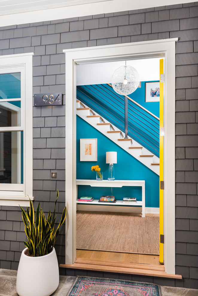 Foto de puerta principal contemporánea con paredes azules, suelo de madera en tonos medios, puerta simple, puerta amarilla y suelo marrón