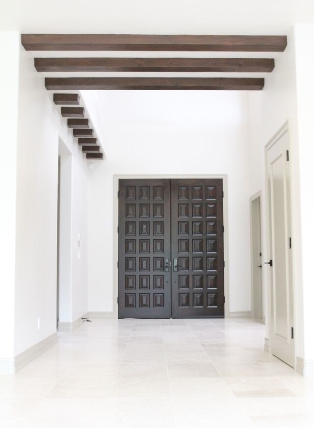 Idée de décoration pour une grande porte d'entrée design avec un mur blanc, une porte double, une porte en bois foncé, un sol en carrelage de porcelaine et un sol blanc.