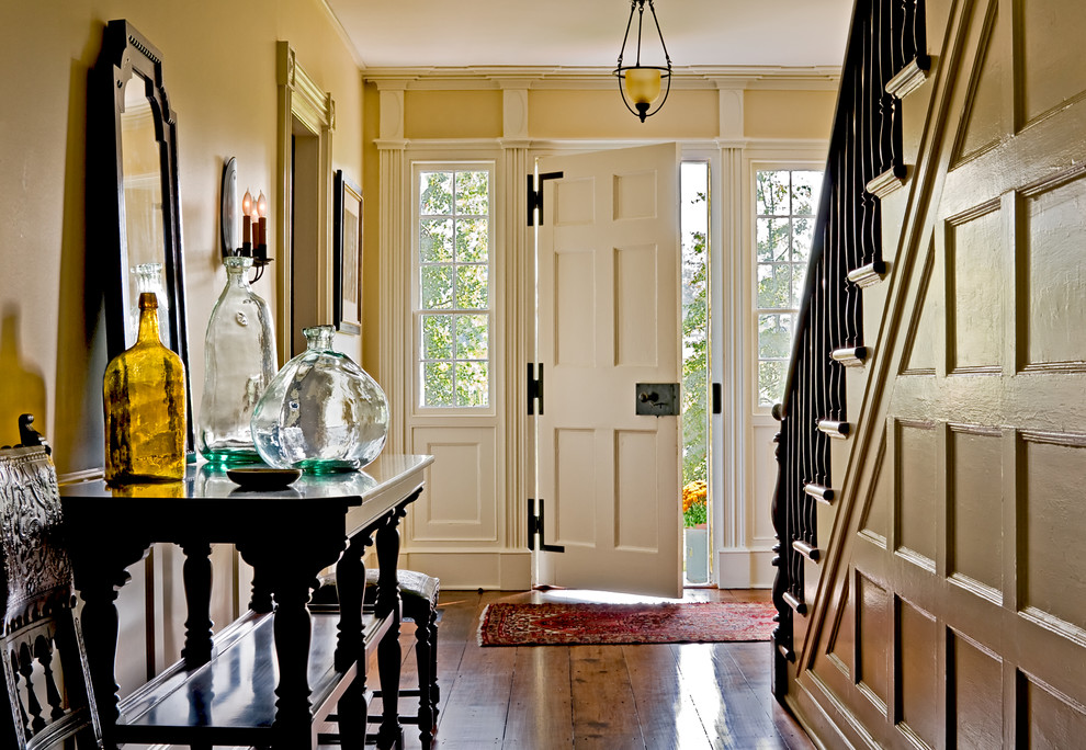 Foto på en vintage foajé, med gula väggar, en enkeldörr och en vit dörr