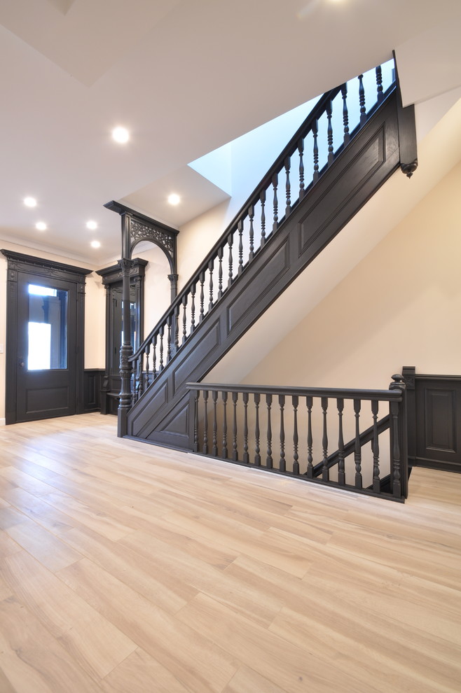 Inspiration for a mid-sized victorian light wood floor entryway remodel in New York with beige walls and a black front door