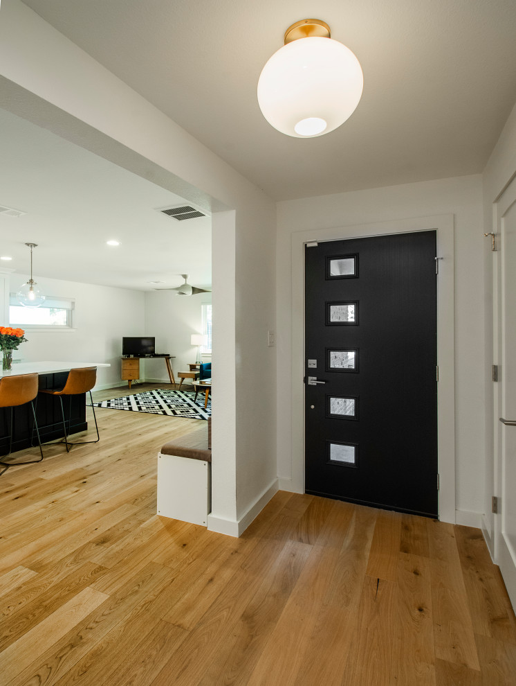 Small front door in Dallas with white walls, medium hardwood flooring, a single front door, a brown front door and brown floors.