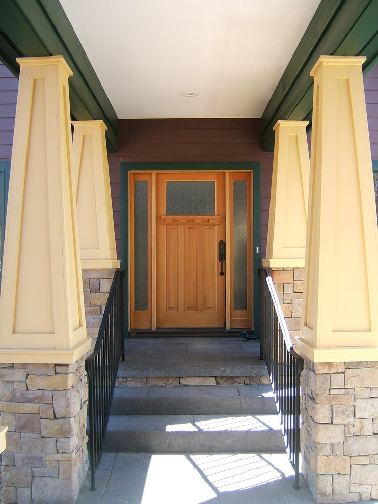 Ejemplo de puerta principal de estilo americano de tamaño medio con paredes rojas, puerta simple y puerta de madera clara