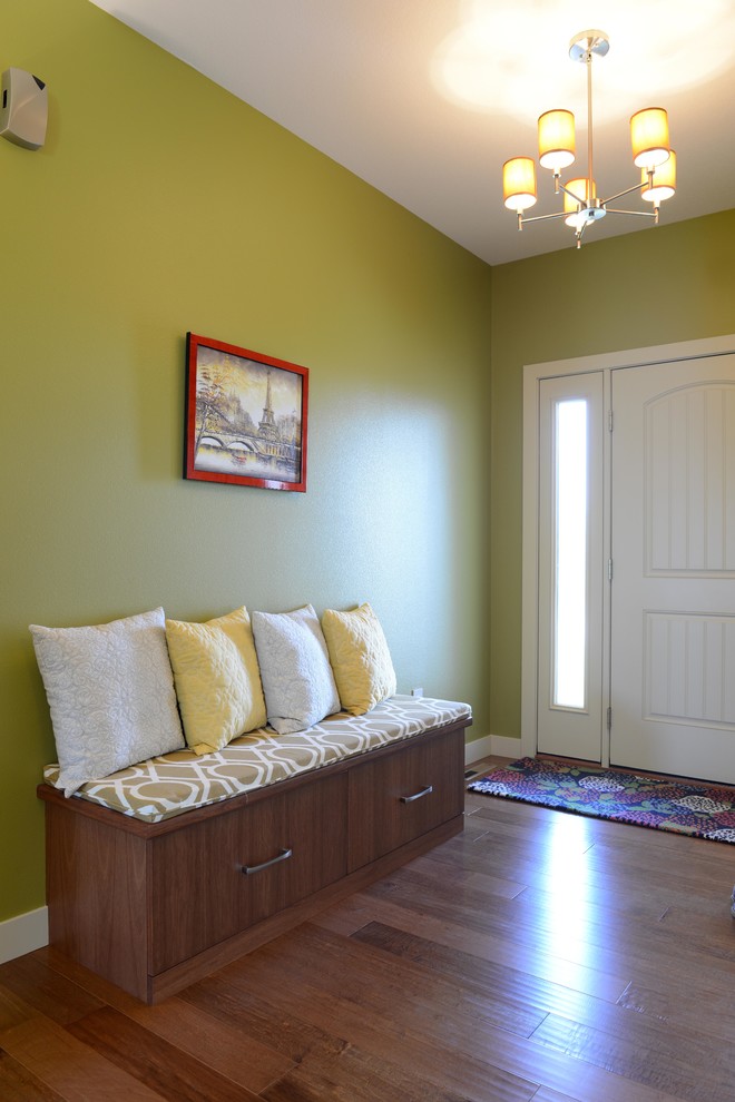 Idee per un piccolo ingresso classico con pareti verdi, pavimento in legno massello medio, una porta singola e una porta bianca
