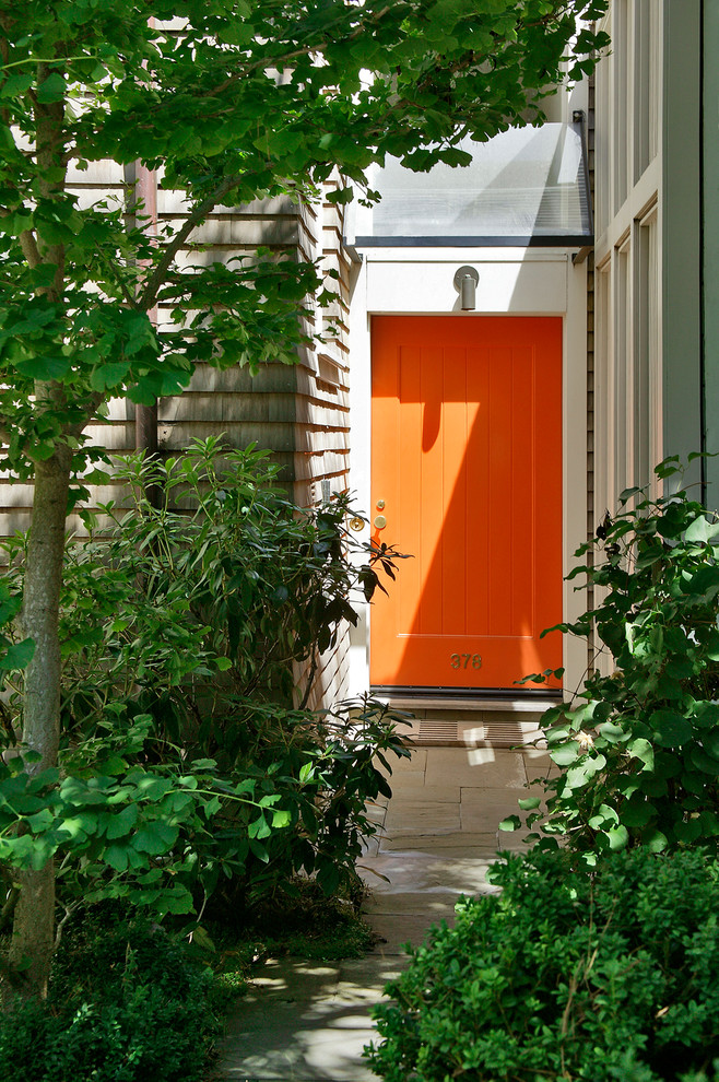 Eklektisk inredning av en ingång och ytterdörr, med en enkeldörr och en orange dörr