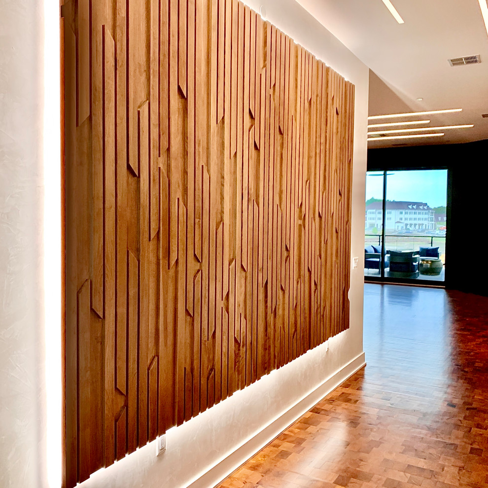 Imagen de hall moderno grande con paredes blancas, suelo de madera en tonos medios, puerta simple, puerta de madera oscura y suelo marrón