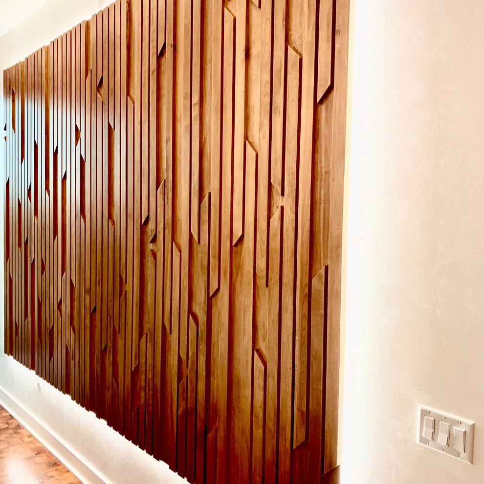 Modelo de hall minimalista grande con paredes blancas, suelo de madera en tonos medios, puerta simple, puerta de madera oscura y suelo marrón