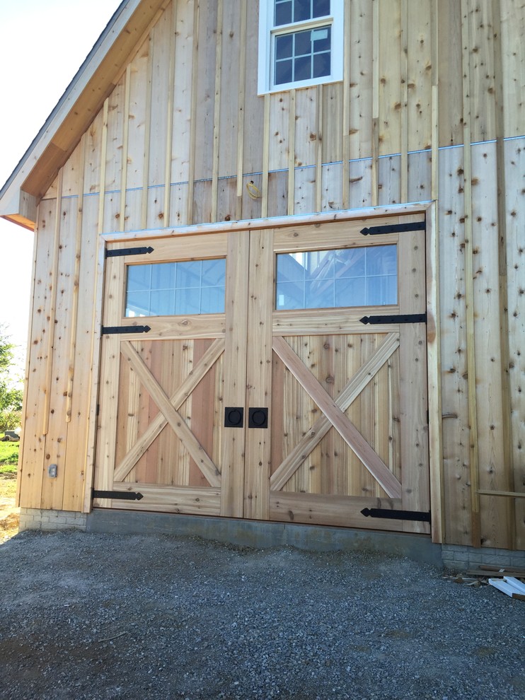 Réalisation d'une grande porte d'entrée champêtre avec sol en béton ciré, une porte double et une porte en bois brun.