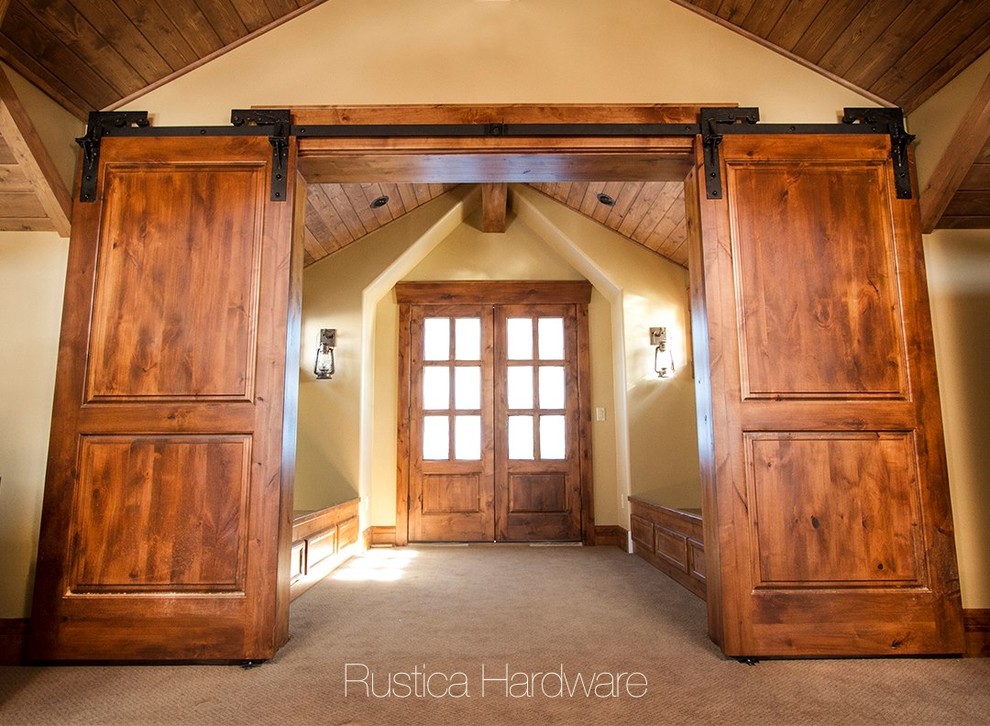 Mountain style carpeted and brown floor entryway photo in Salt Lake City with beige walls