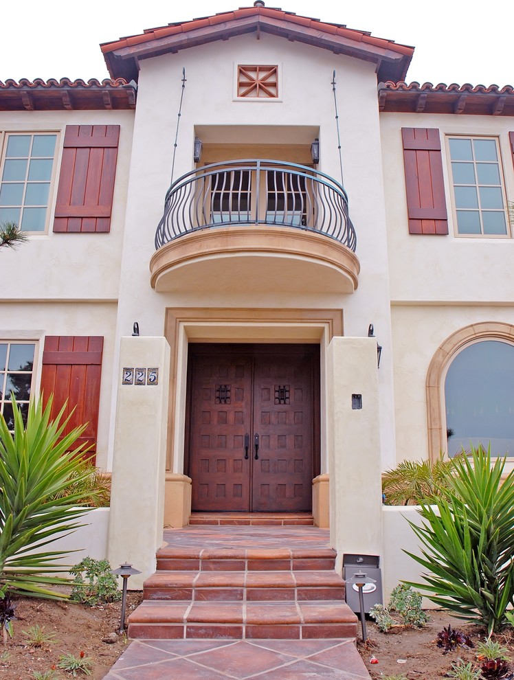 Modelo de puerta principal mediterránea grande con paredes beige, suelo de baldosas de terracota, puerta doble, puerta marrón y suelo beige