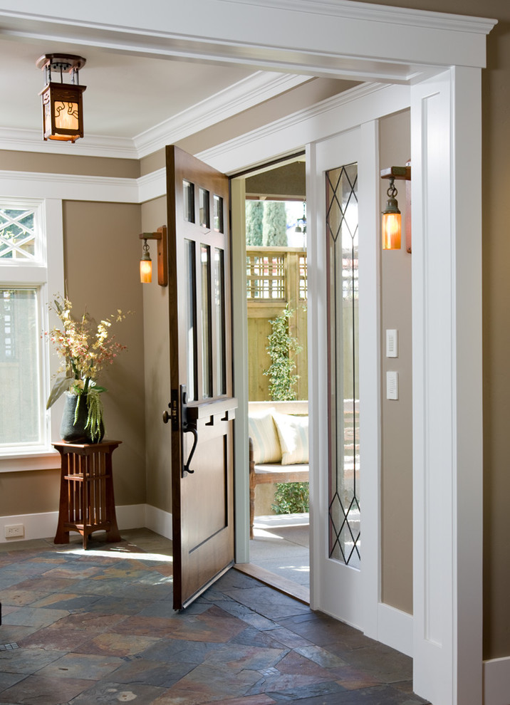 Ispirazione per un ingresso o corridoio american style con pareti marroni, pavimento in ardesia, una porta in legno scuro e una porta singola