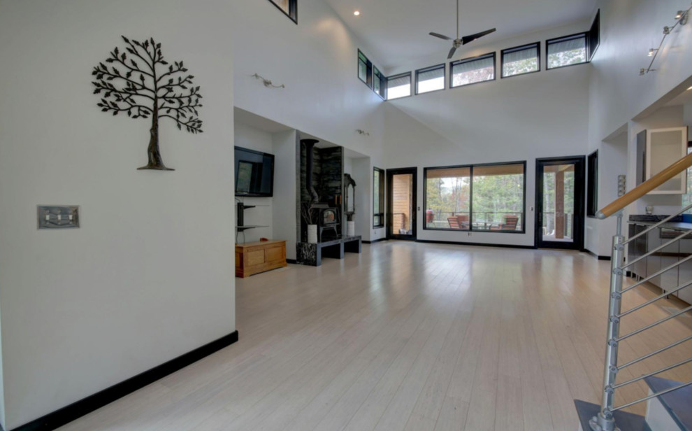 Example of a mid-sized trendy light wood floor and beige floor entryway design in Other with white walls and a glass front door
