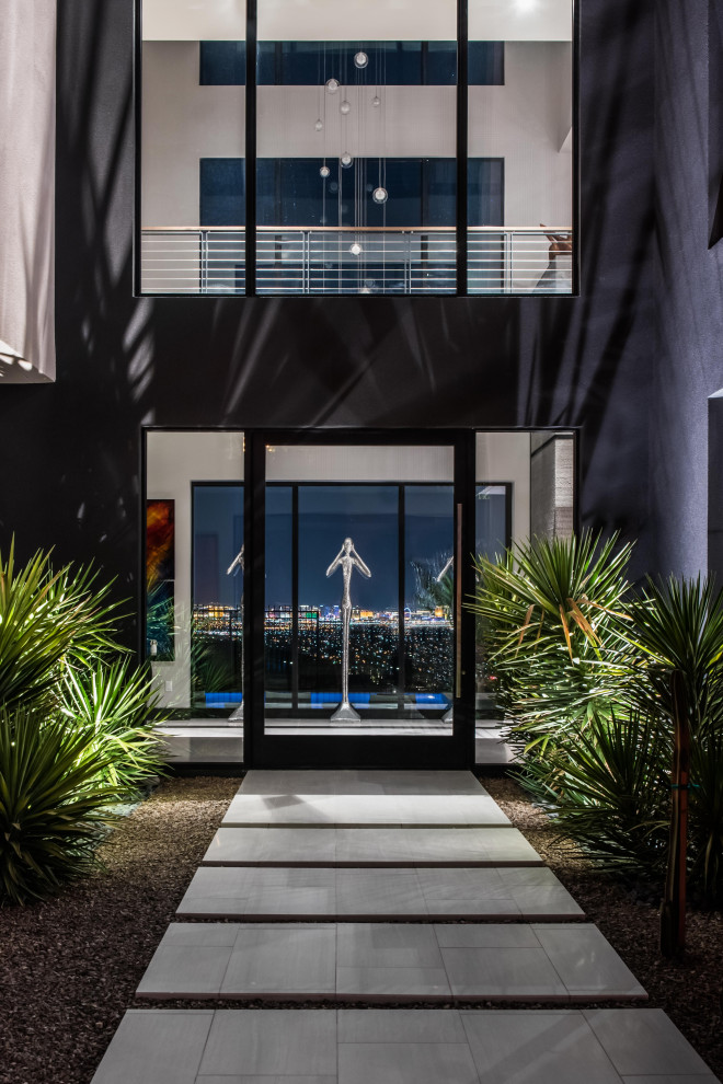 Inspiration for a large contemporary front door in Las Vegas with a pivot front door and a glass front door.
