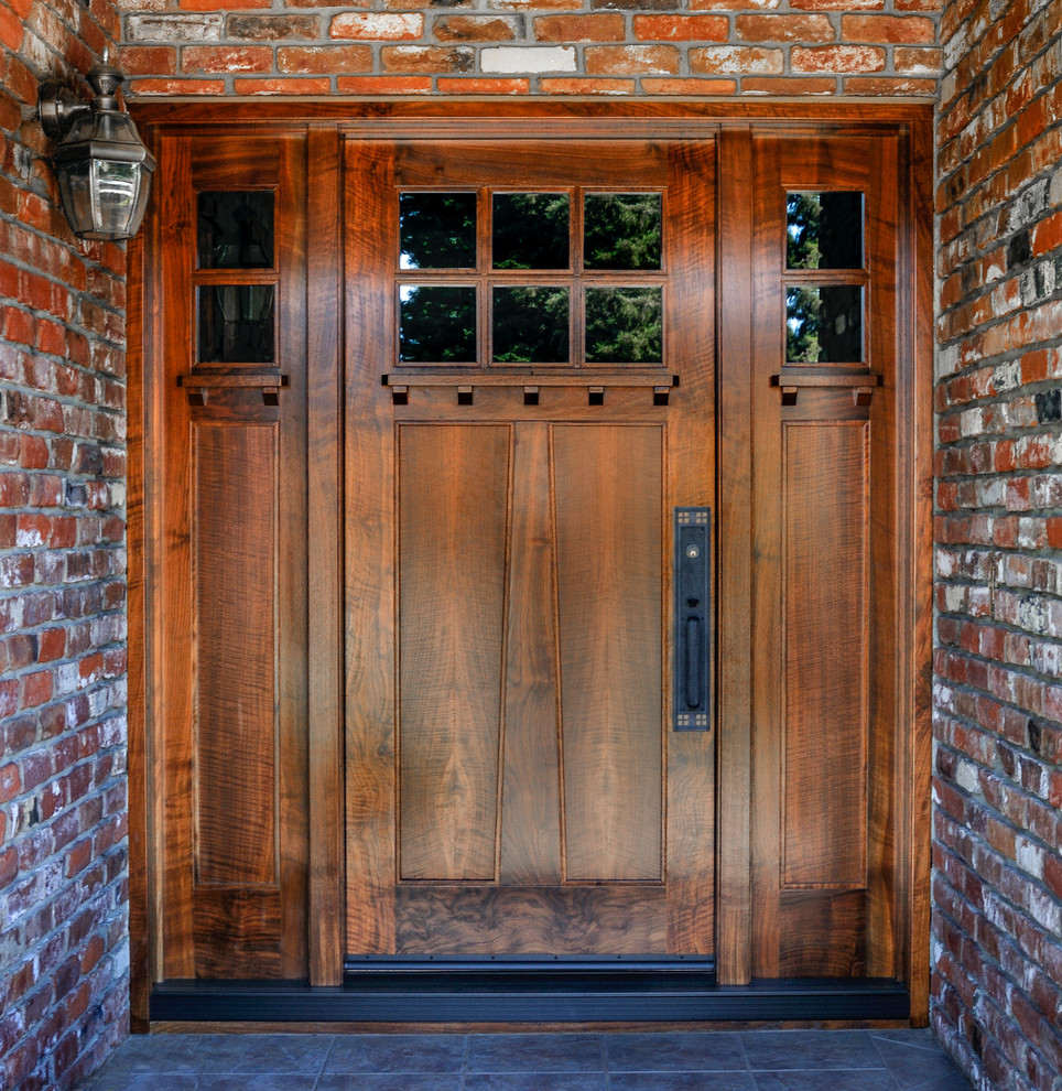 Idées déco pour une grande porte d'entrée craftsman avec un mur rouge, un sol en ardoise, une porte simple et une porte en bois brun.