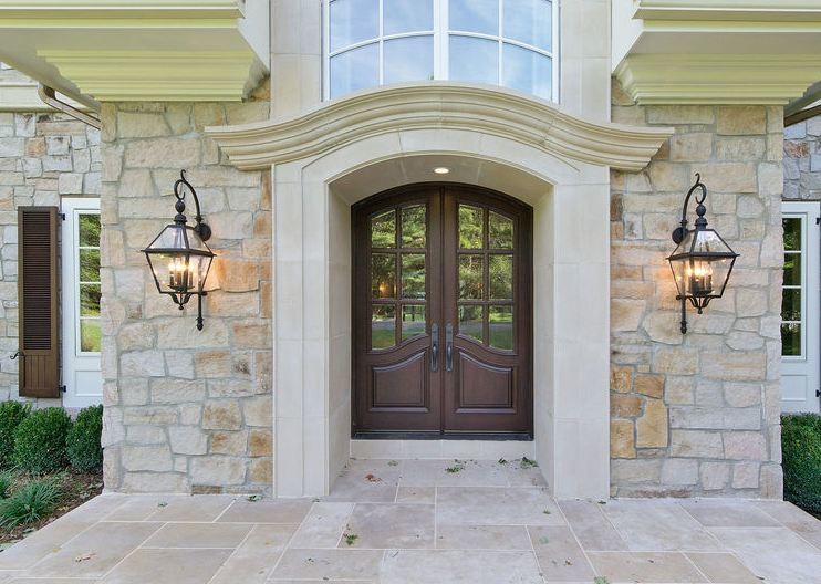 Idée de décoration pour une grande porte d'entrée avec un mur beige, un sol en terrazzo, une porte double et une porte marron.