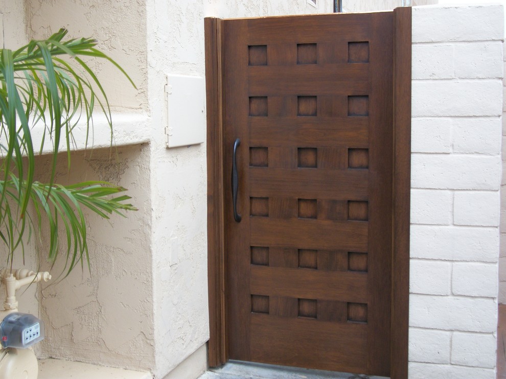 Immagine di una porta d'ingresso rustica di medie dimensioni con pareti bianche, pavimento in travertino, una porta singola, una porta in legno scuro e pavimento beige