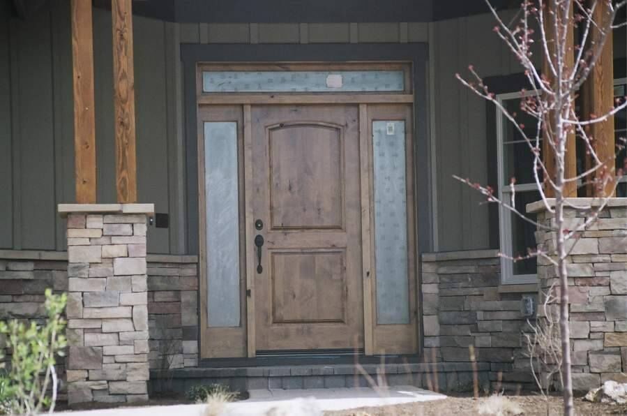 Immagine di una porta d'ingresso stile rurale di medie dimensioni con una porta singola e una porta in legno bruno