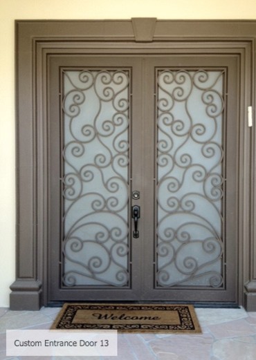 ロサンゼルスにあるお手頃価格の中くらいなコンテンポラリースタイルのおしゃれな玄関ドア (茶色い壁、レンガの床、金属製ドア) の写真