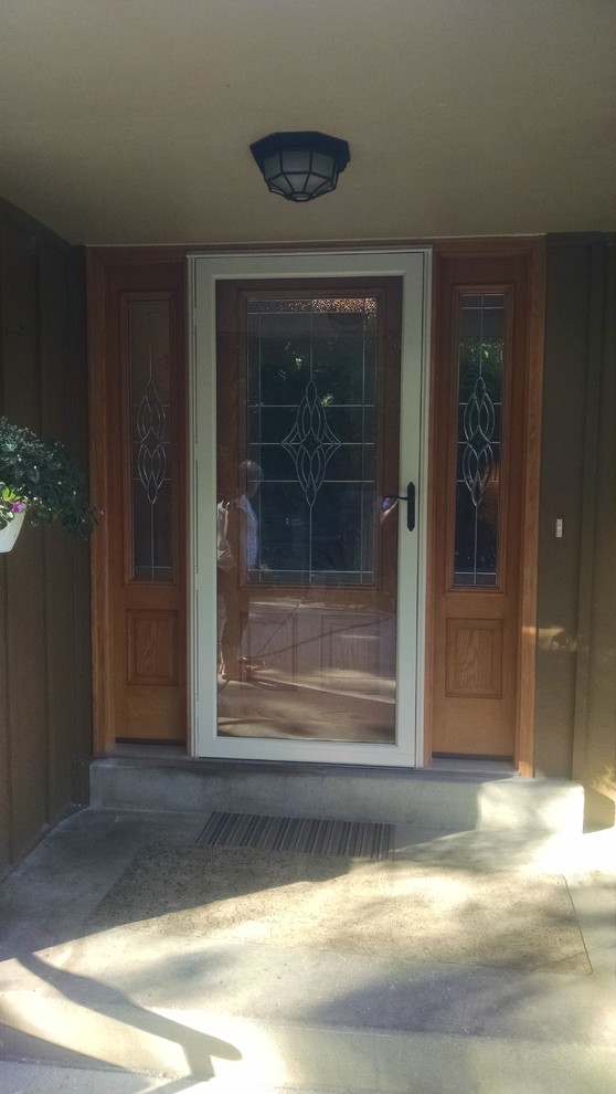 Modelo de puerta principal tradicional grande con paredes beige, suelo de madera en tonos medios, puerta simple y puerta de madera en tonos medios