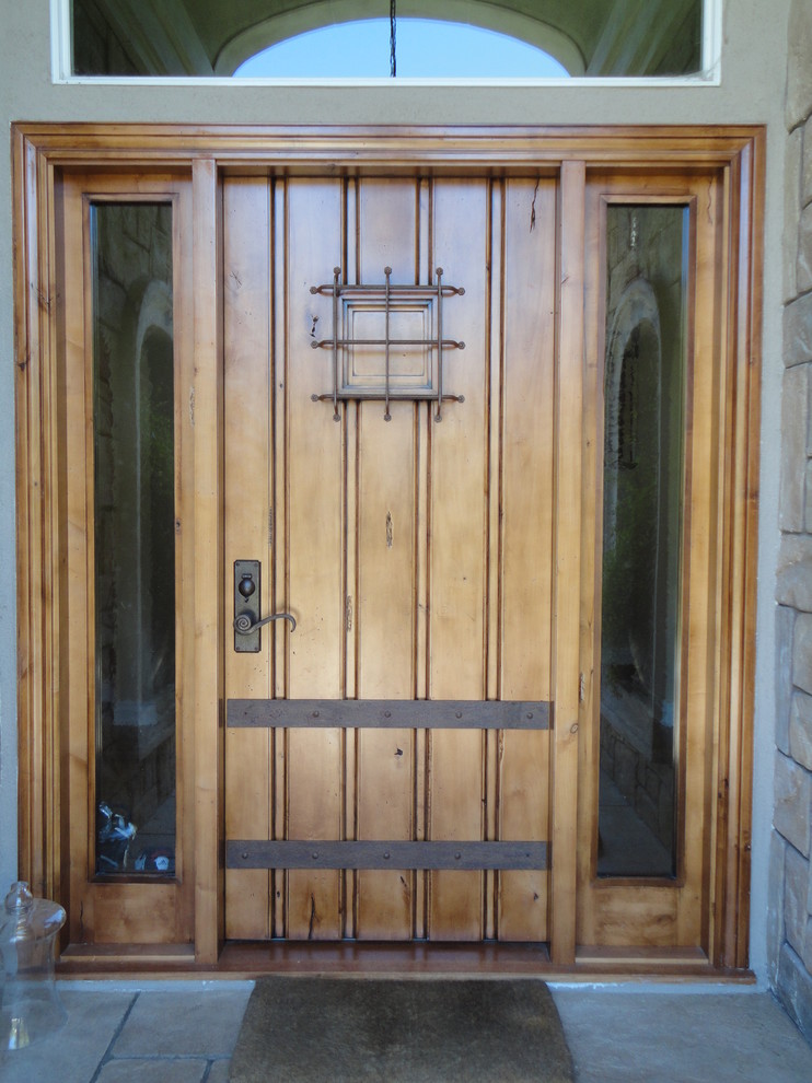 Idee per una porta d'ingresso mediterranea con una porta singola e una porta in legno chiaro