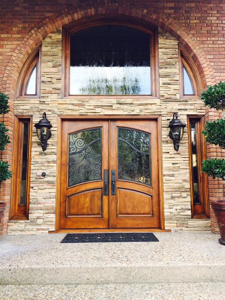 Ispirazione per una porta d'ingresso classica con pareti beige, pavimento in cemento, una porta a due ante e una porta in legno bruno