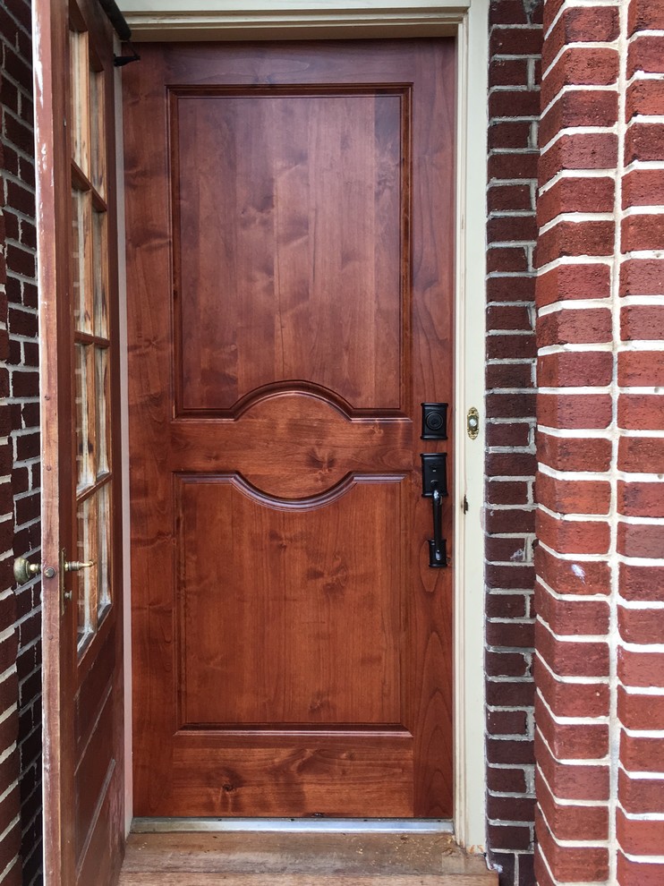 Foto de puerta principal tradicional de tamaño medio con paredes rojas, suelo de ladrillo, puerta simple, puerta de madera oscura y suelo rojo