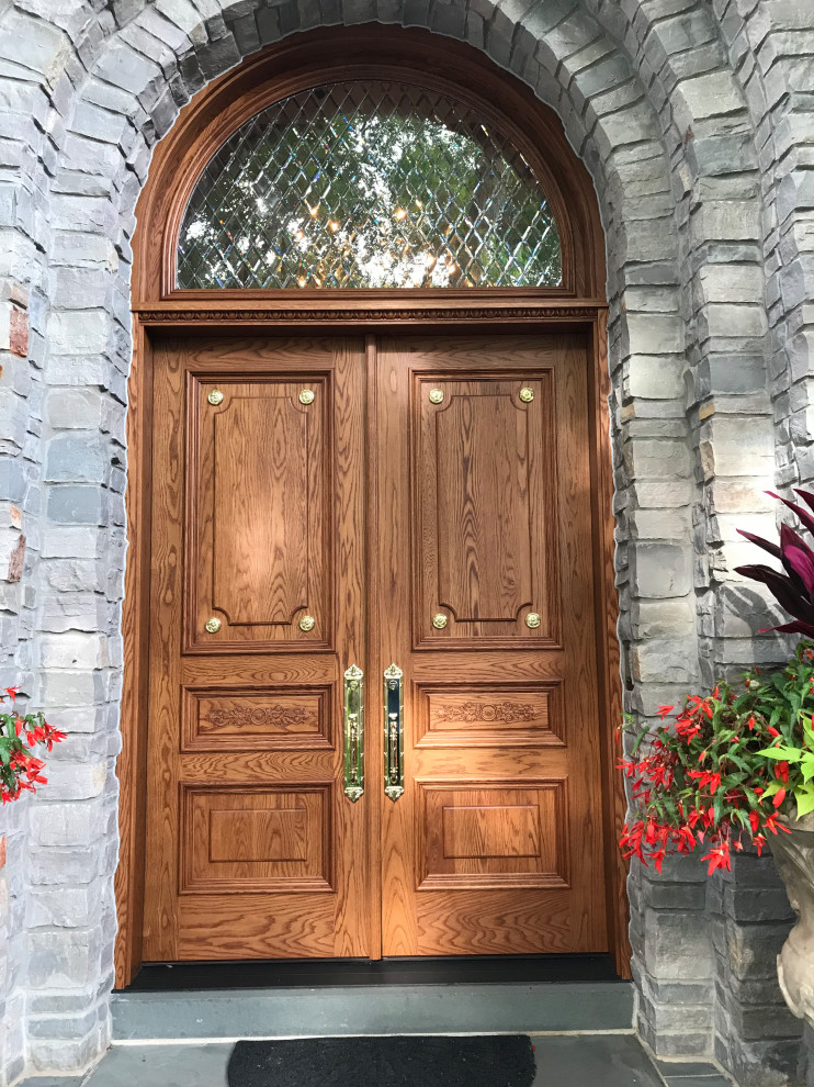 シカゴにある高級な広い地中海スタイルのおしゃれな玄関ドア (木目調のドア) の写真