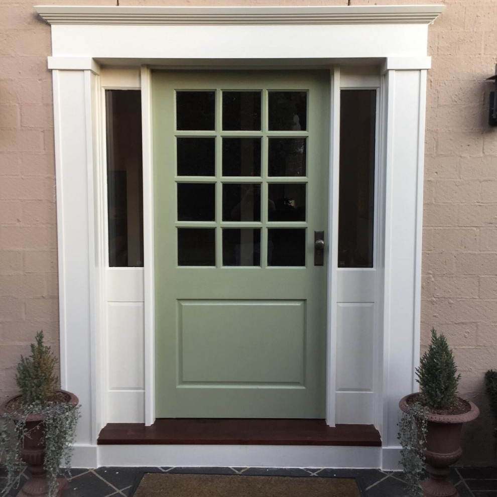 Foto de puerta principal tradicional de tamaño medio con paredes beige, suelo de baldosas de cerámica, puerta simple, puerta verde, suelo gris y ladrillo