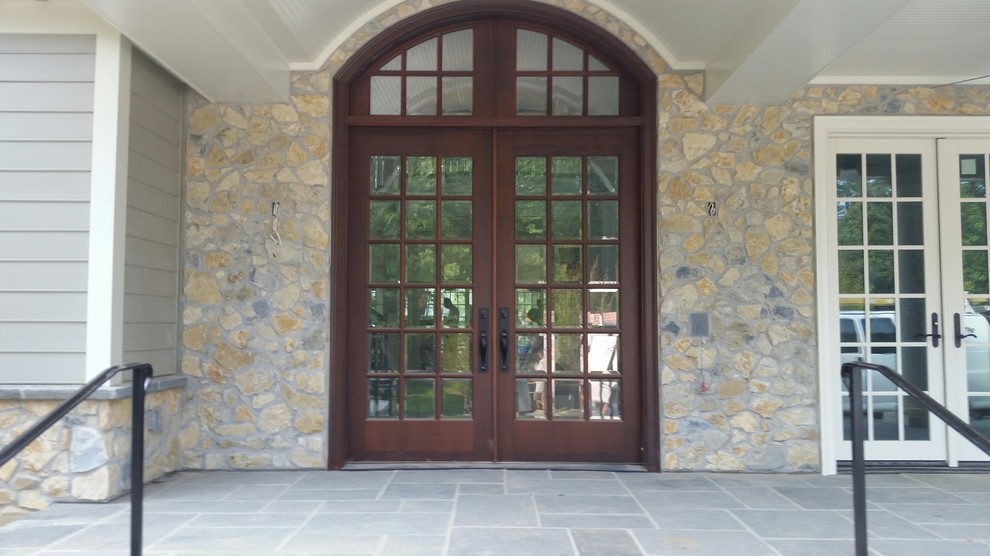 Diseño de entrada clásica con suelo de pizarra, puerta doble y puerta de madera oscura