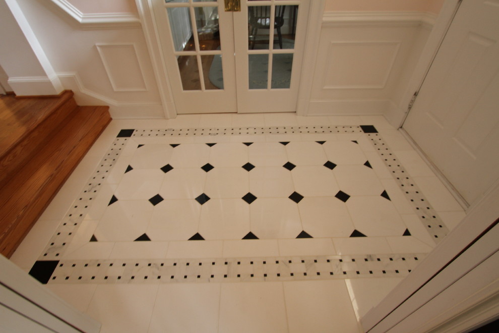 This is an example of a medium sized traditional foyer in DC Metro with pink walls and marble flooring.