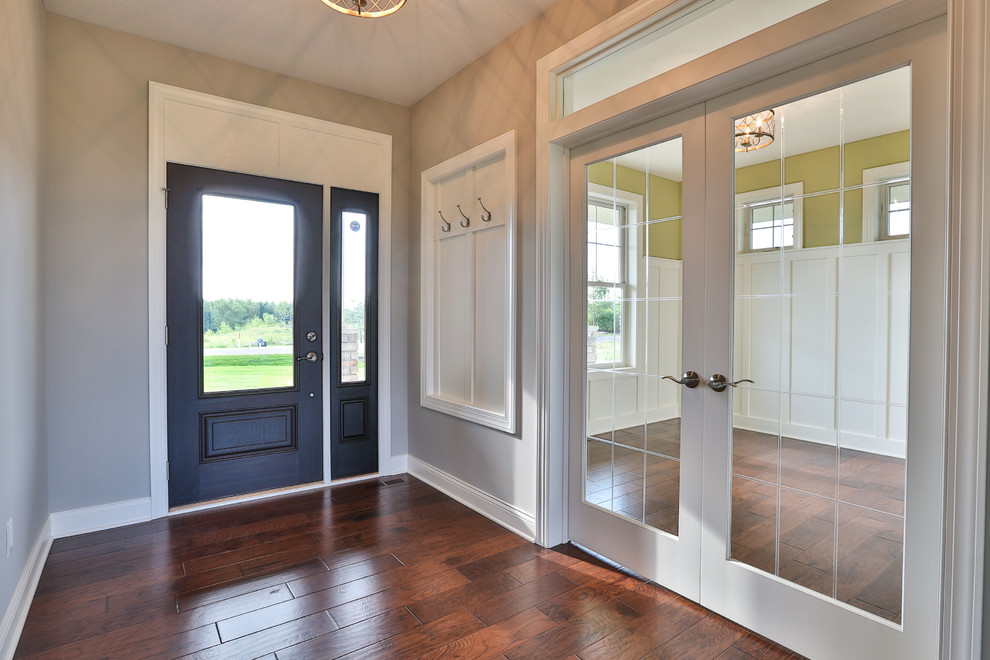 Mittelgroße Haustür mit beiger Wandfarbe, braunem Holzboden, Einzeltür und Haustür aus Glas in Minneapolis