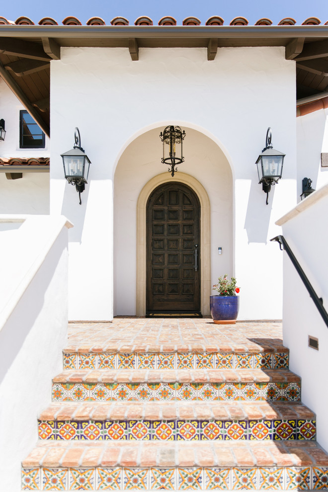 Mediterrane Haustür mit weißer Wandfarbe, Backsteinboden, Einzeltür, dunkler Holzhaustür und rotem Boden in San Luis Obispo