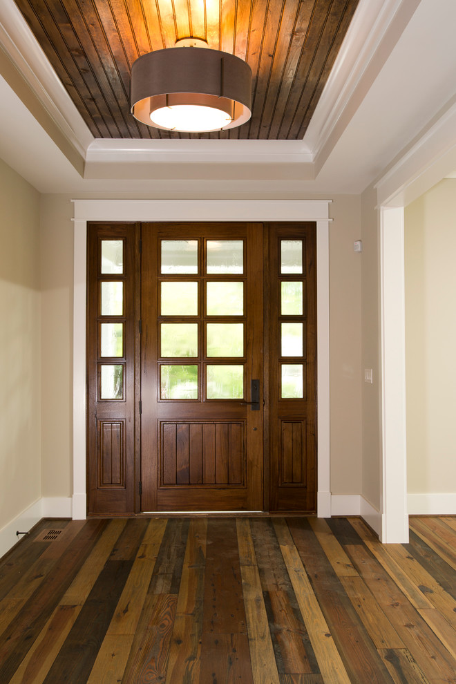 Imagen de entrada clásica con paredes beige, puerta simple, puerta de madera oscura y suelo de madera en tonos medios