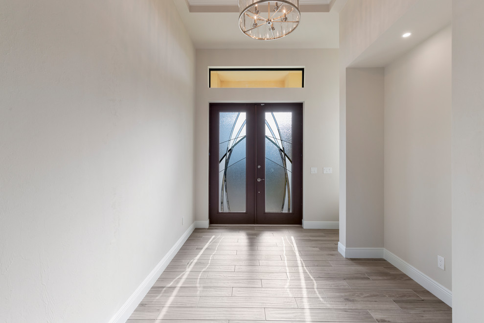 На фото: большое фойе в современном стиле с полом из керамогранита, двустворчатой входной дверью и коричневой входной дверью с