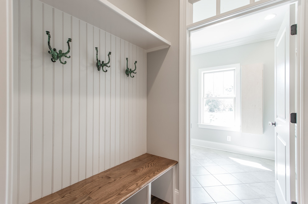 Idée de décoration pour une petite entrée style shabby chic avec un vestiaire, un mur gris et un sol en bois brun.