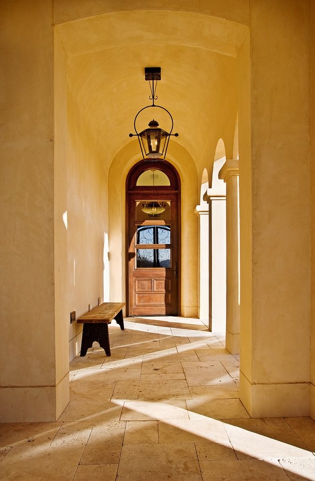 Cette photo montre une porte d'entrée méditerranéenne avec un mur beige.
