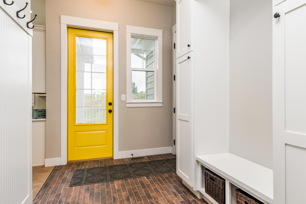 Ispirazione per una porta d'ingresso country di medie dimensioni con pareti grigie, una porta singola, una porta gialla e pavimento marrone