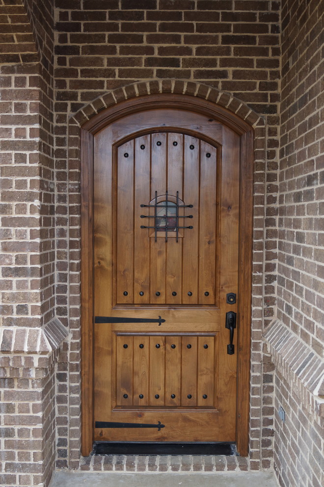Example of a small classic concrete floor entryway design in Dallas with brown walls and a medium wood front door