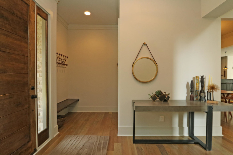 Example of a mid-sized trendy light wood floor and beige floor entryway design in Atlanta with white walls and a dark wood front door