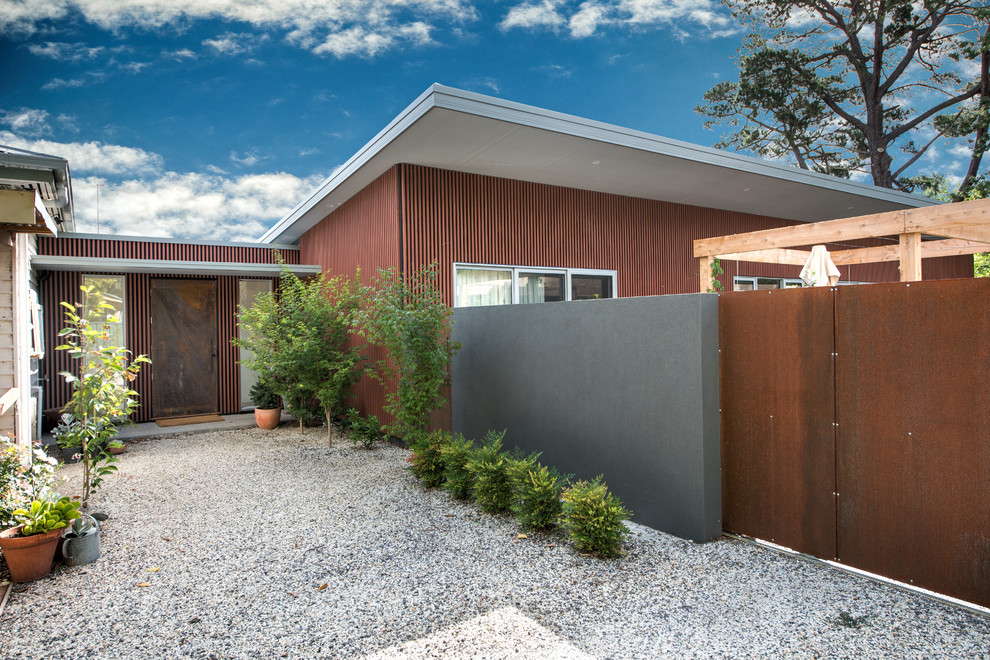 Inspiration for a modern front door in Melbourne with brown walls, a single front door and a metal front door.