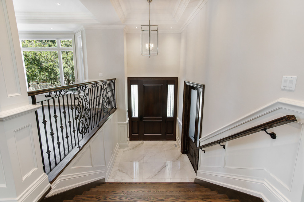 Example of a mid-sized transitional porcelain tile and white floor entryway design in Toronto with gray walls and a dark wood front door
