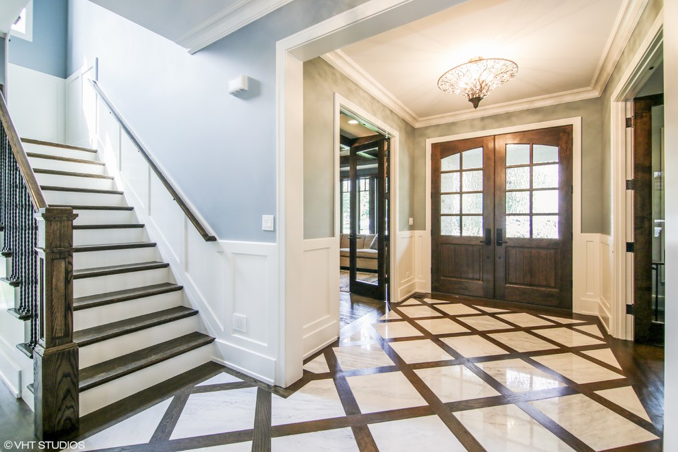 This is an example of a traditional foyer in Chicago with grey walls, dark hardwood flooring, a double front door, a dark wood front door and beige floors.