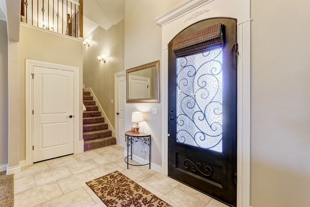 Immagine di una porta d'ingresso tradizionale di medie dimensioni con pareti beige, pavimento con piastrelle in ceramica, una porta singola, una porta in metallo e pavimento beige