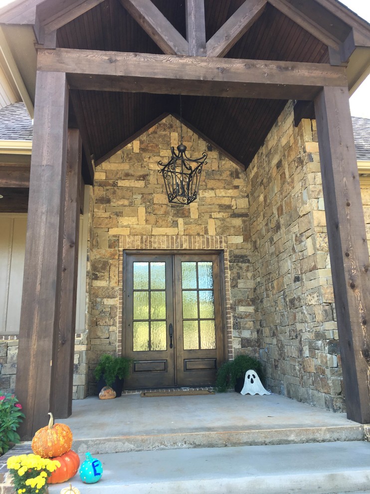 На фото: входная дверь среднего размера в стиле рустика с бежевыми стенами, бетонным полом, двустворчатой входной дверью и входной дверью из темного дерева с
