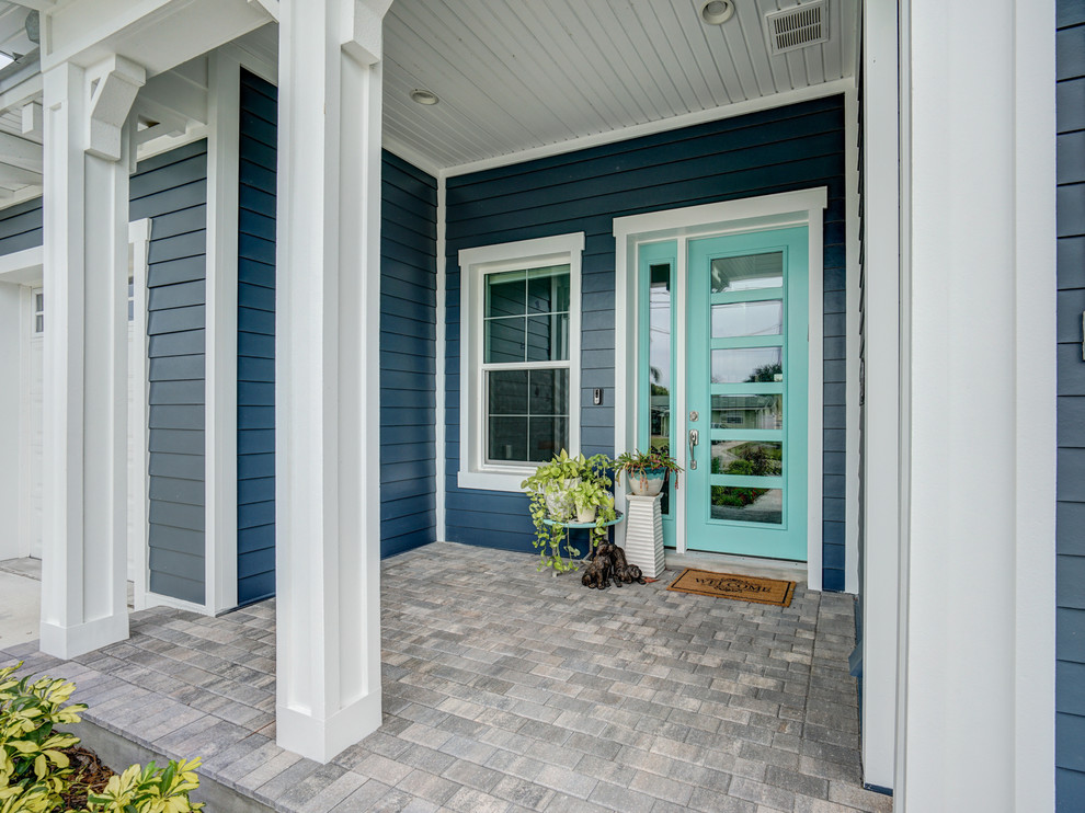 Diseño de puerta principal costera de tamaño medio con paredes azules, suelo de ladrillo, puerta simple, puerta azul y suelo beige