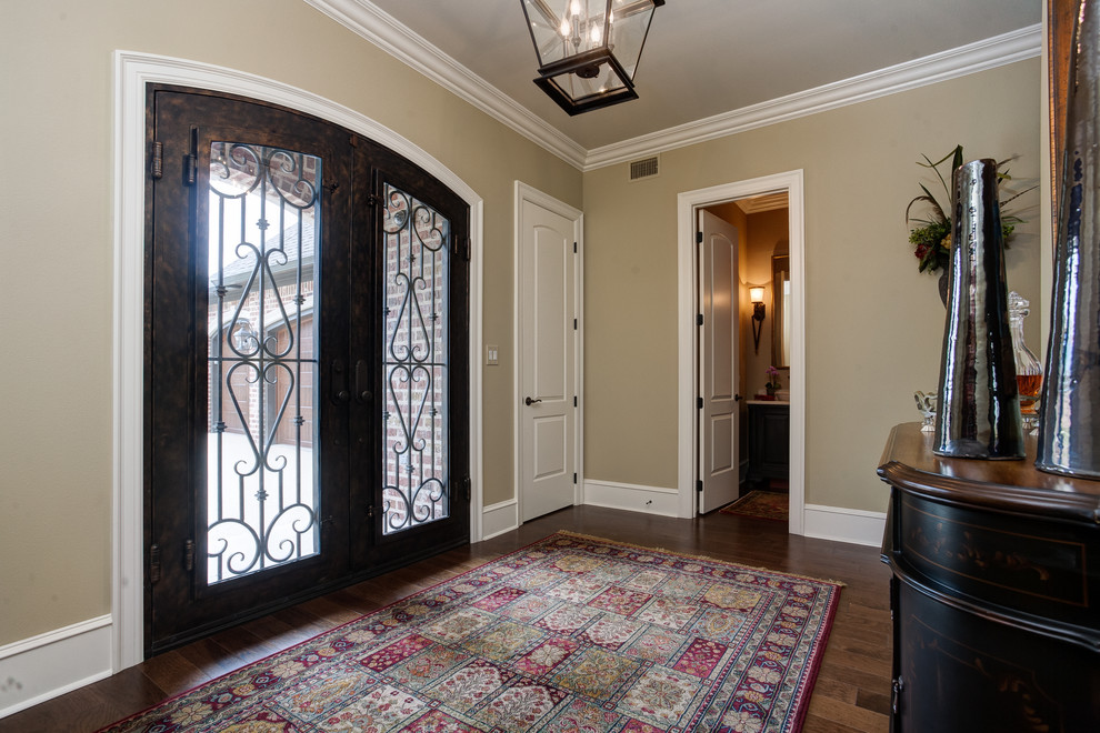 Пример оригинального дизайна: большое фойе в классическом стиле с бежевыми стенами, темным паркетным полом, двустворчатой входной дверью, входной дверью из темного дерева и коричневым полом