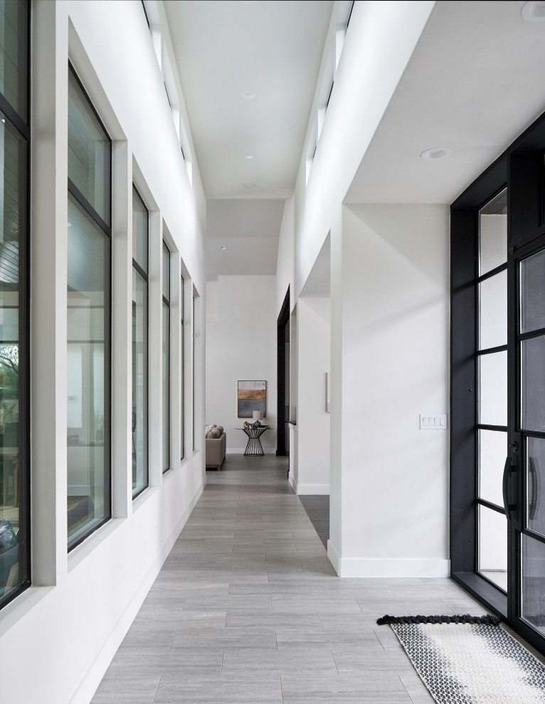 Esempio di un ingresso tradizionale con pareti bianche, pavimento in gres porcellanato, una porta singola, una porta in vetro e pavimento grigio