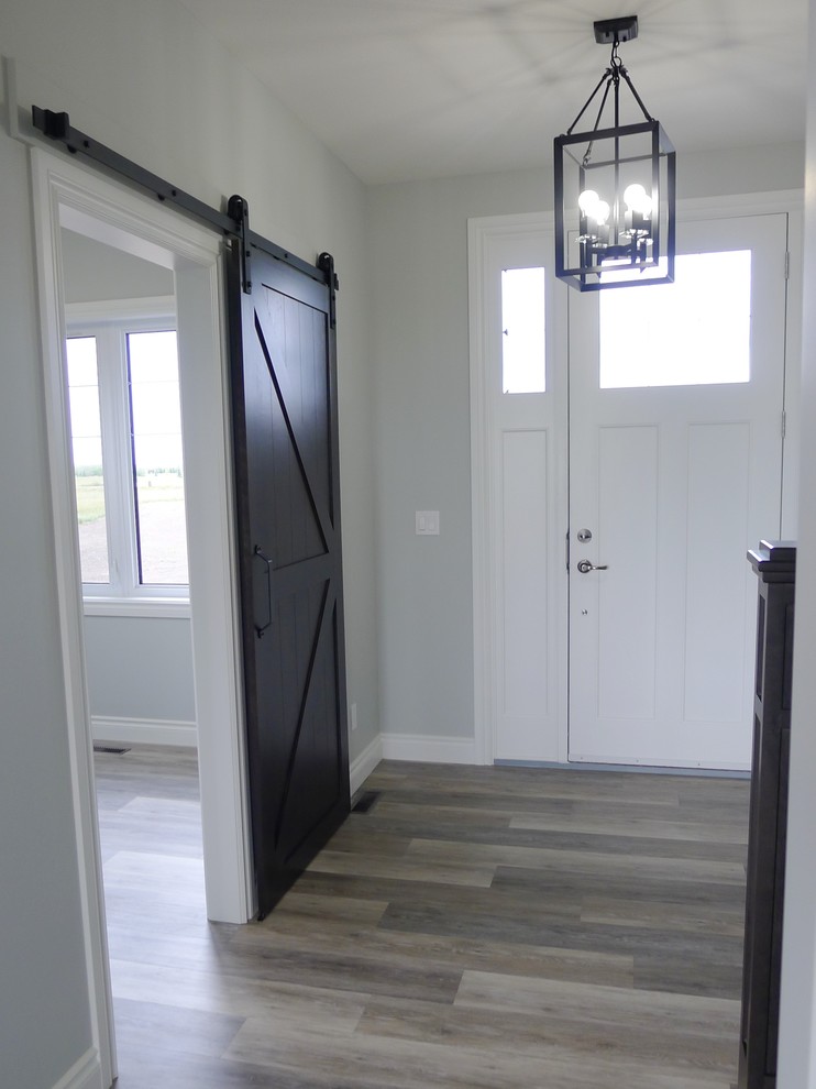 Foto de puerta principal contemporánea pequeña con paredes grises, suelo vinílico, puerta simple, puerta blanca y suelo marrón