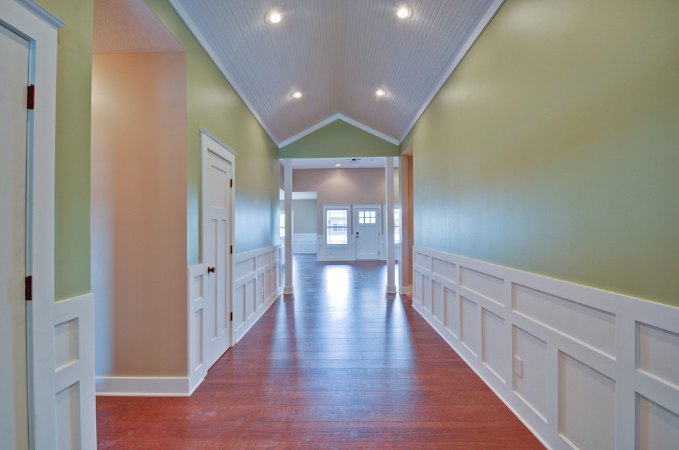 Mittelgroßes Rustikales Foyer mit grüner Wandfarbe, braunem Holzboden, Einzeltür und schwarzer Haustür in Indianapolis